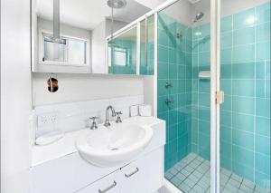 un bagno con lavandino e doccia in vetro di Mooloolaba Waterfront Two Story Unit with Pontoon a Mooloolaba