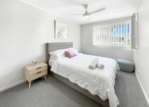 una camera da letto con un grande letto bianco e una finestra di Mooloolaba Waterfront Two Story Unit with Pontoon a Mooloolaba