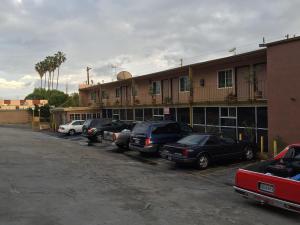 a parking lot with cars parked in front of a building at Highland Park Motel in Los Angeles