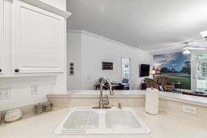 a kitchen with a sink and a living room at Birdies & Beaches in Hampstead +45 photos