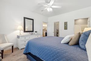 a bedroom with a blue bed and a ceiling fan at Birdies & Beaches in Hampstead