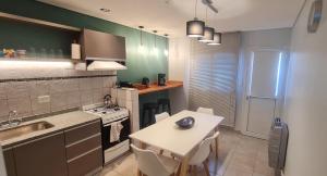 a kitchen with a table and a sink and a stove at Duplex Portugal Tw in Trelew