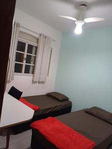 a room with two beds and a window at Jardim Santa Rosália in Sorocaba