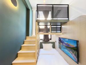 Habitación con escalera, cama y TV. en Coliwoo 268 River Valley - CoLiving, en Singapur