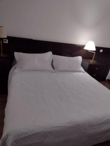 a large bed with white sheets and pillows at Apart Bayres Obelisco in Buenos Aires +8 photos