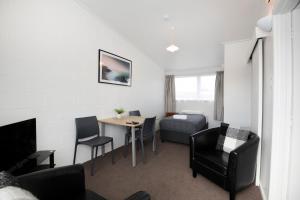 ein Wohnzimmer mit Tisch und Stühlen und einer Couch in der Unterkunft Spanish Lady Motel in Napier