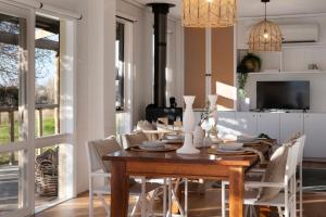 a dining room with a wooden table and white chairs at The Cottage at Lake Werona in Werona