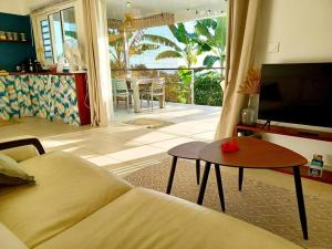 a living room with a couch and a table at Fare Outu Iti in Punaauia
