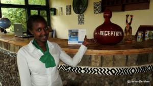 a woman standing in front of a counter with a vase at Le Bambou Gorilla Lodge in Ruhengeri