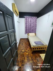 Habitación pequeña con cama y puerta en Glory Beach Seaview Family Home, en Port Dickson