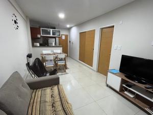 Una sala de estar con un sofá y un televisor. en Bellísimo departamento de un dormitorio, ubicación inmejorable, en Rosario