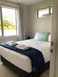 Un dormitorio con una cama grande con toallas. en Wanaka Holiday, en Wanaka