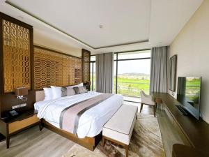 a bedroom with a large bed and a large window at Phoenix Pool & Golf View Villa Cam Ranh in Cam Ranh