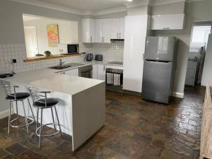 a kitchen with a counter and a refrigerator at Stylishly renovated bungalow in Orange