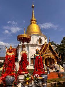 a pagoda with two statues in front of a building at Entire Home with King Bed in Chiang Mai