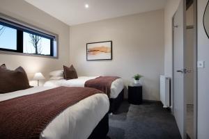 デイルスフォードにあるRetreat Lake Daylesford - Free Wifiのベッドが2つと窓があるホテルの部屋