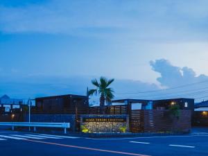 IchinomiyaSeage Torami Coastside的一条街道旁的棕榈树建筑