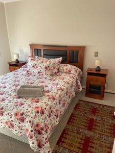 a bedroom with a large bed with a floral bedspread at Departamento Aníbal Pinto Concepción in Concepción