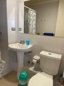 a bathroom with a sink and a toilet and a mirror at Departamento Aníbal Pinto Concepción in Concepción