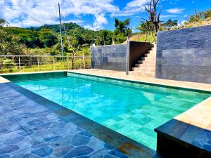 a swimming pool with blue water in a yard at El Diamante - Finca Privada con Piscina Barbosa in Barbosa