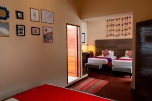 a bedroom with two beds and a mirror at Union Hotel Cusco in Cusco
