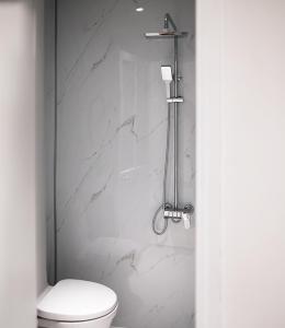 a bathroom with a toilet and a marble wall at BenHouse Homestay in Ho Chi Minh City +53 photos
