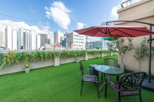 a patio with a table and two chairs and an umbrella at New Cheonji Hotel in Seoul