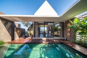 an indoor swimming pool in a house at Oasis Loft - Ricefield Luxe View Ubud in Ubud