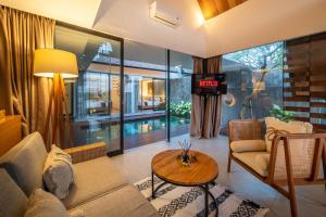 a living room with a couch and a table at Oasis Loft - Ricefield Luxe View Ubud in Ubud