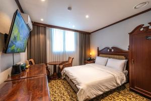 ソウルにあるNew Cheonji Hotelのベッドと机があるホテルの部屋 +105枚の写真