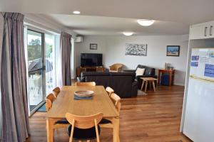 una sala de estar con una mesa y un sofá en Ocean Shores Apartment 14 - Bring your own linen., en South West Rocks