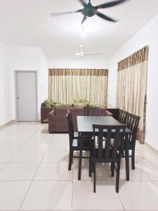 a dining room with a table and chairs and a couch at IJM Condostay, Sandakan in Sandakan