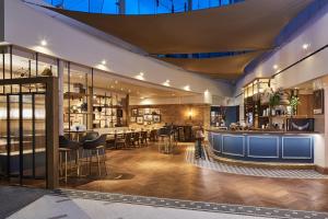 a restaurant with a bar and tables and chairs at London Marriott Hotel Kensington in London
