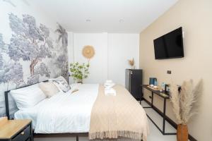a bedroom with a bed and a tv on a wall at Mitsu Guesthouse in Karon Beach