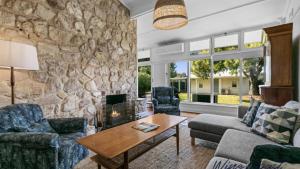 a living room with a stone wall at Vintage Vista By Wine Coast Holidays in Port Willunga