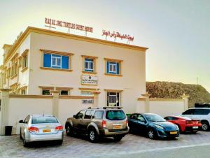 a group of cars parked in front of a building at Turtle Guest House in Sur