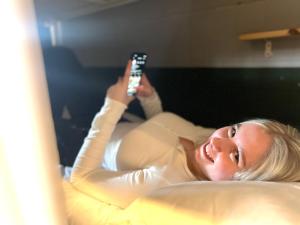 a woman laying in bed holding a remote control at G Guesthouse Itaewon In Seoul in Seoul