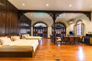 a bedroom with two beds and a table and chairs at FOREST - Fong Lee CC Lampang Walking Street in Lampang