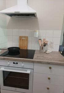 a kitchen with a stove with a frying pan on it at Saunallinen viihtyisä kaksio keskustan tuntumassa in Kouvola +7 photos