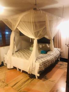 蒙巴萨Lusigi Luxe villas的客房内的白色床和天蓬