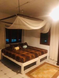 蒙巴萨Lusigi Luxe villas的卧室内的一张带天蓬的床 更多51张照片