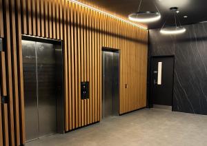 a row of elevators in a building with wooden walls at Central & Chic in the Capital in Wellington