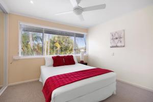 a bedroom with a white bed and a window at Moondarah: Pet-Friendly Escape in Noosa Heads