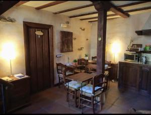 a dining room with a wooden table and chairs at Hotel Rural La Fuente in Patones