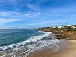 a beach with the ocean and houses in the background at Casa Luz in Luz