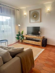 a living room with a couch and a flat screen tv at Casa Luz in Luz