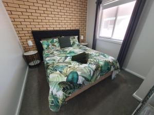 1 dormitorio con 1 cama con edredón verde y ventana en Elliston Apartments, en Elliston