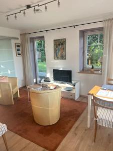 Una sala de estar con una mesa y un televisor. en Wohnung am Rande der Nordheide, en Welle