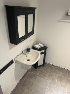 Un baño blanco con lavabo y espejo. en Wohnung am Rande der Nordheide, en Welle