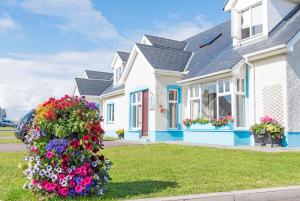 a white house with flowers in front of it at Portbeg Holiday Homes at Donegal Bay in Bundoran